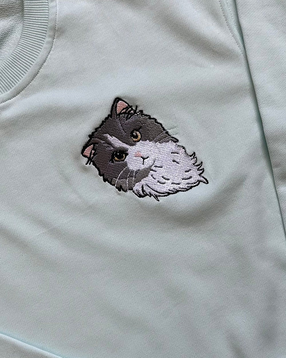Le portrait brodé de son chat sur le pull