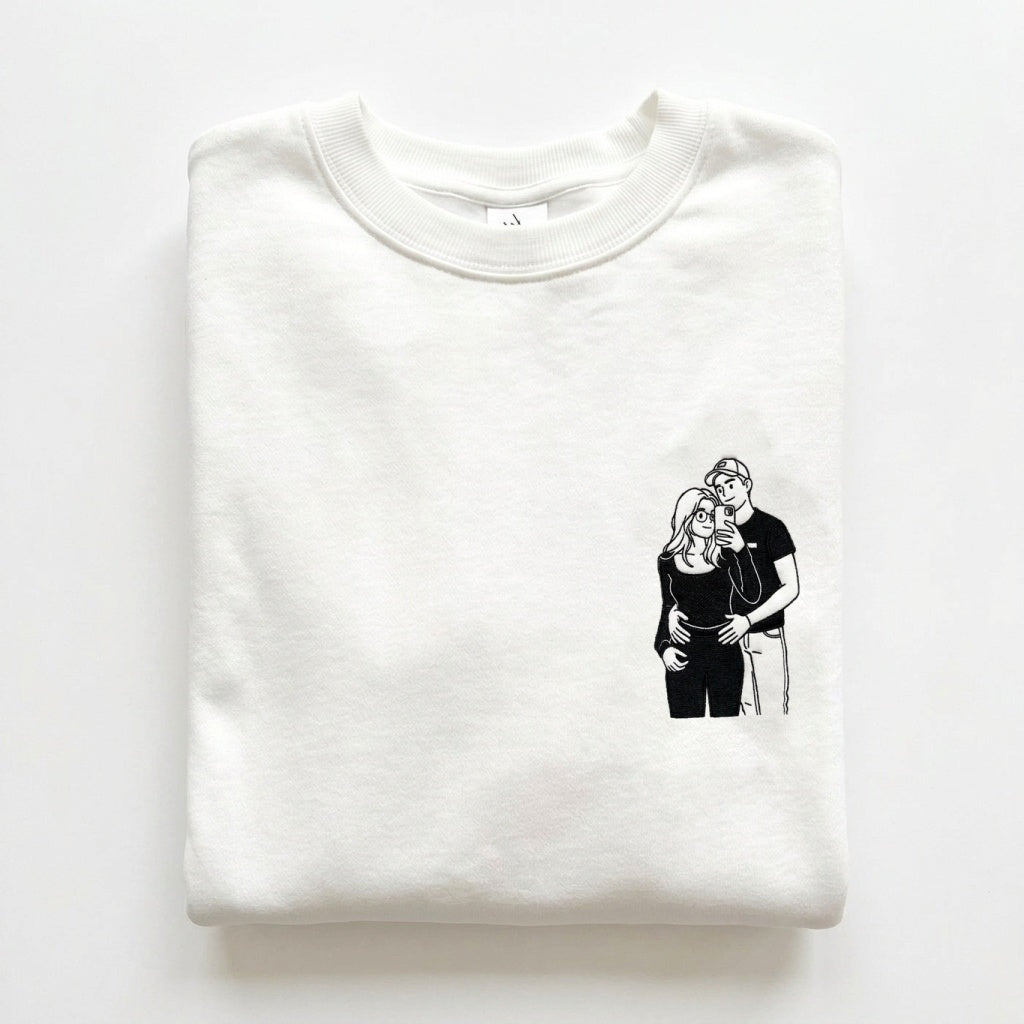 Gros plan de la broderie du dessin de couple sur le pull blanc