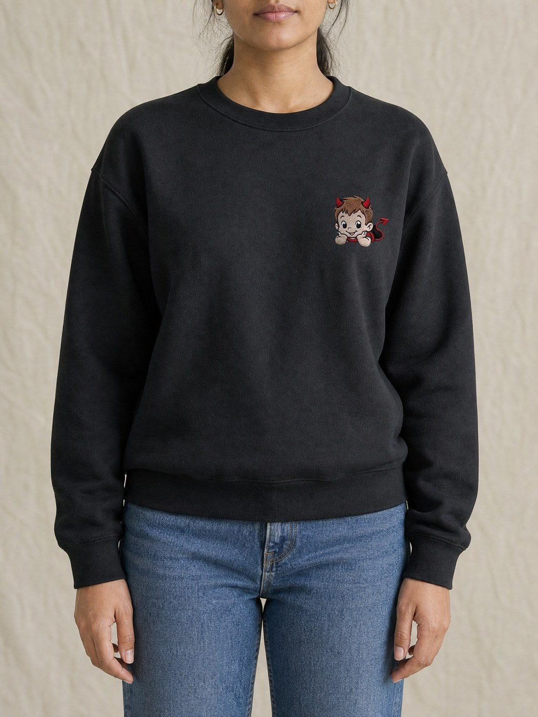 Broderie Démon sur le pull noir, côté cœur