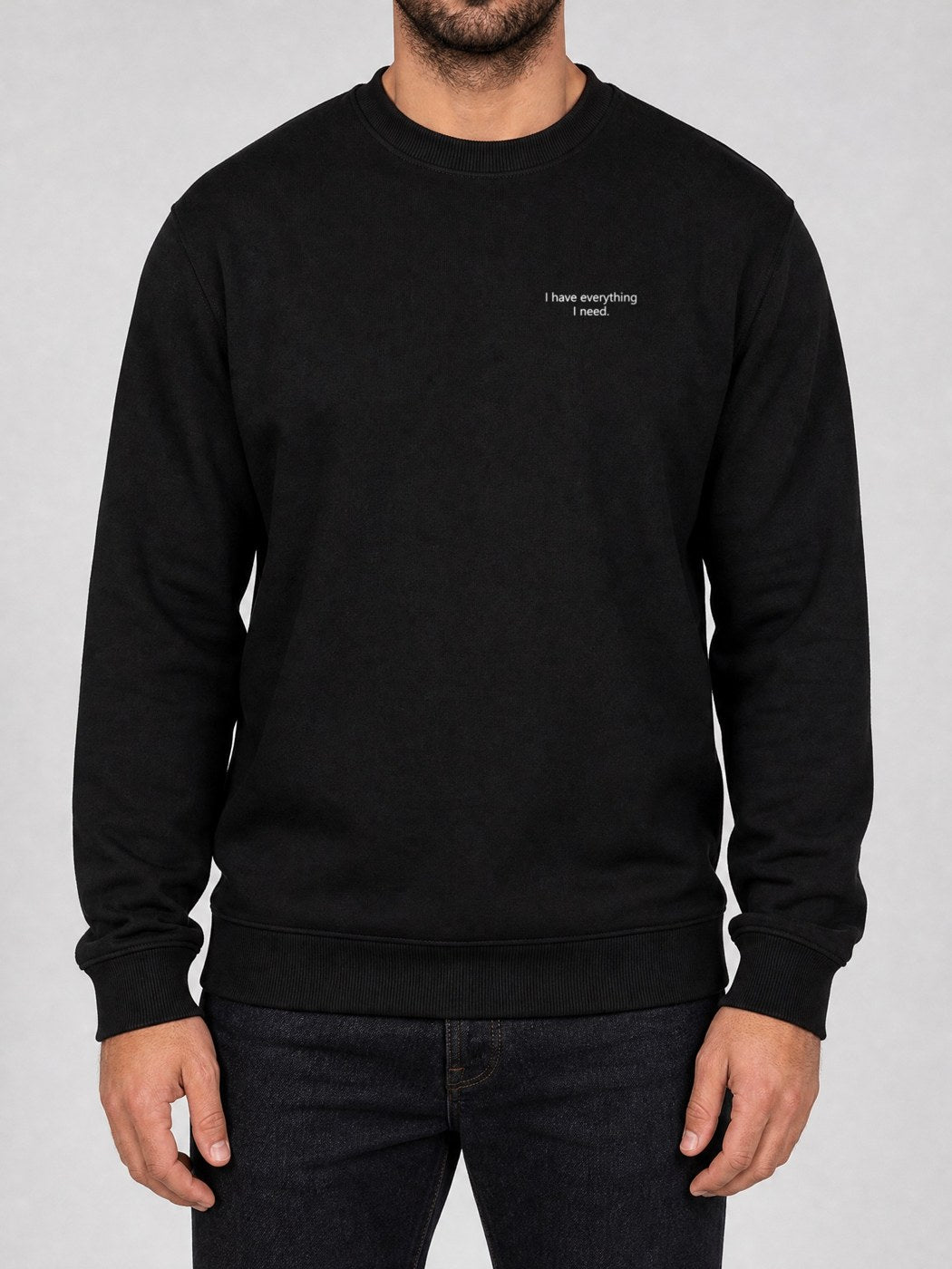 Broderie « I have everything I need. » sur le pull noir, côté cœur
