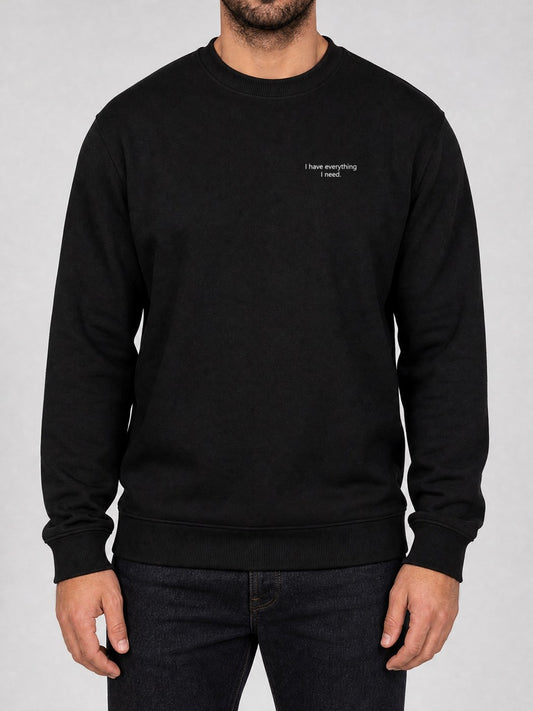 Broderie « I have everything I need. » sur le pull noir, côté cœur