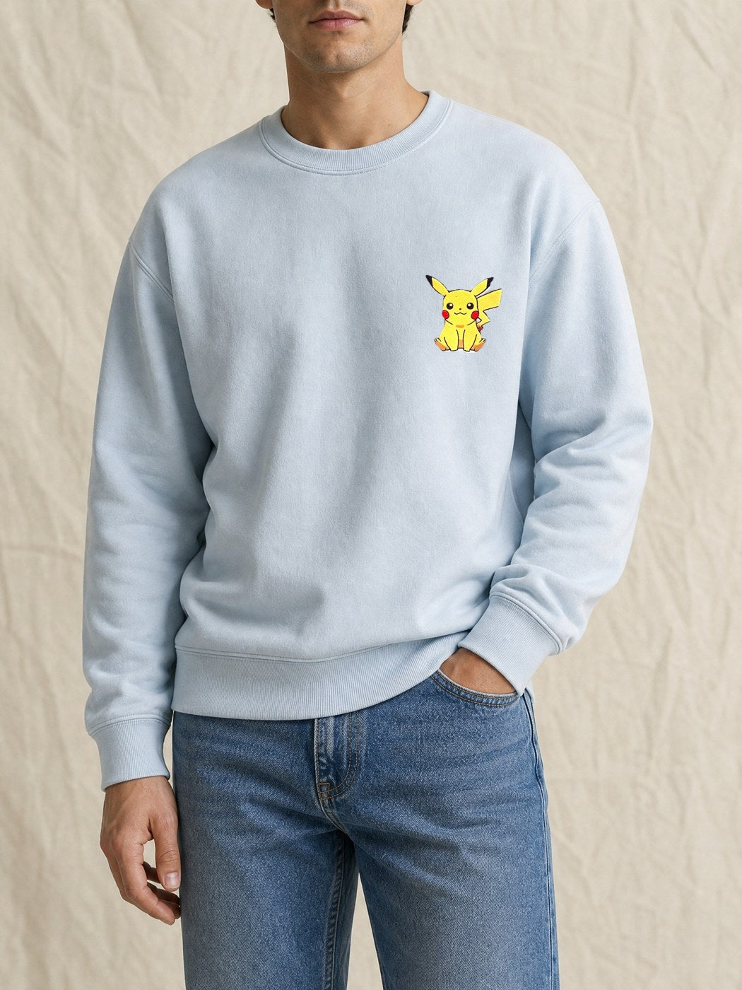 Broderie Pikachu sur le pull bleu ciel, côté cœur