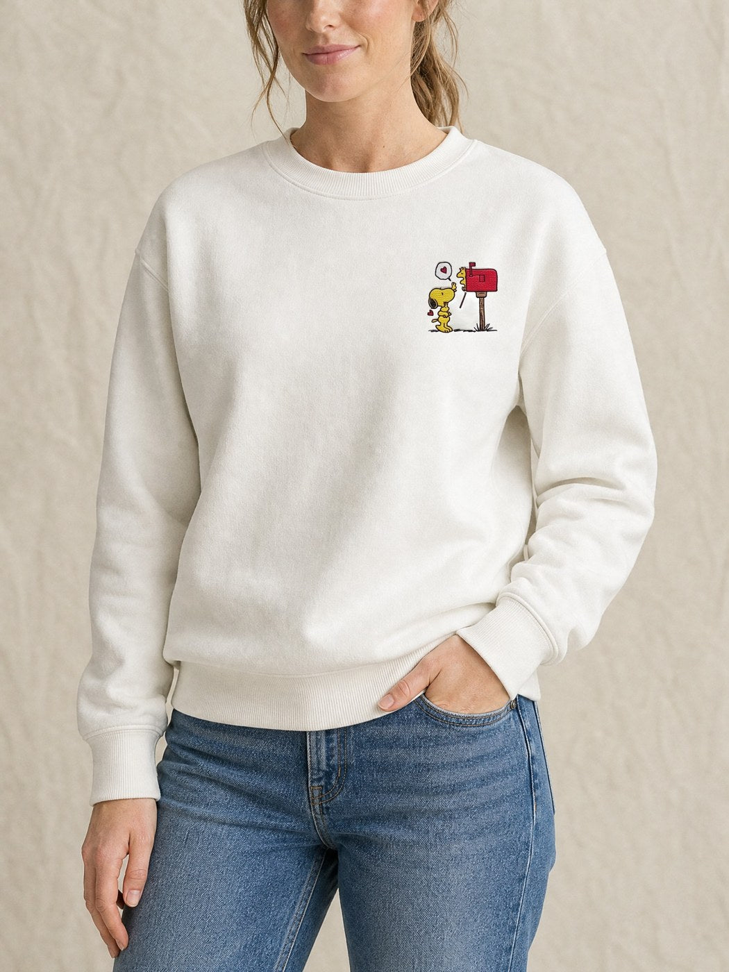 Broderie Woodstock sur le pull blanc, côté cœur