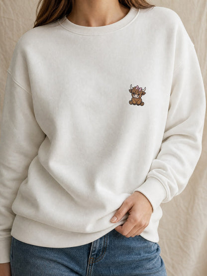 Broderie Vache highland au nœud sur le pull blanc, côté cœur